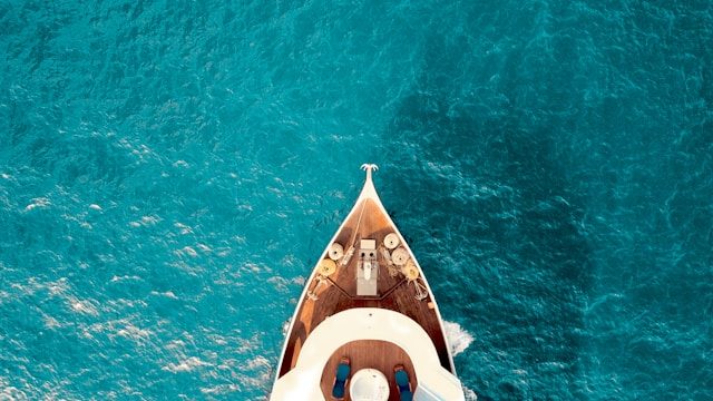 Aerial view of a luxury yacht cutting through turquoise water
