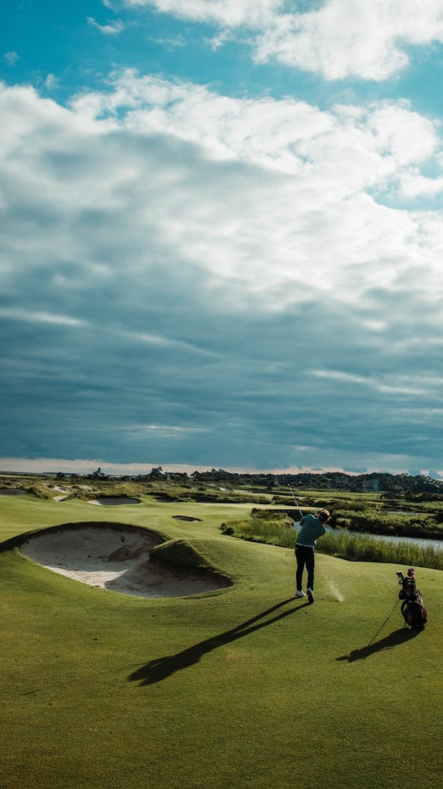 Golfer mid-swing on a coastal championship course