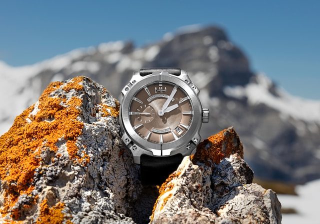 Luxury Swiss wristwatch photographed on alpine rock